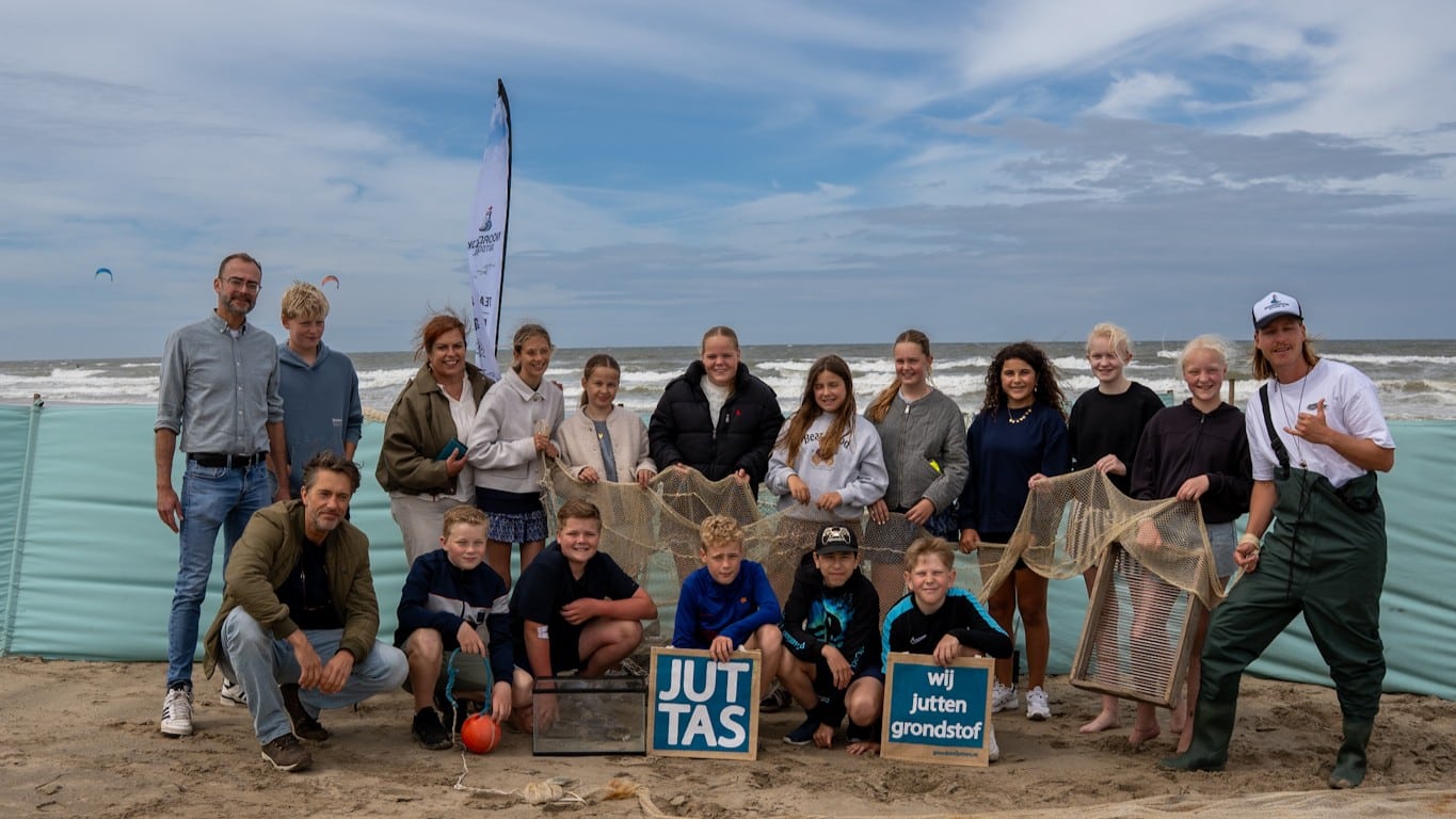 Wethouder Pim van Strien en een groep kinderen samen met een strandjutter