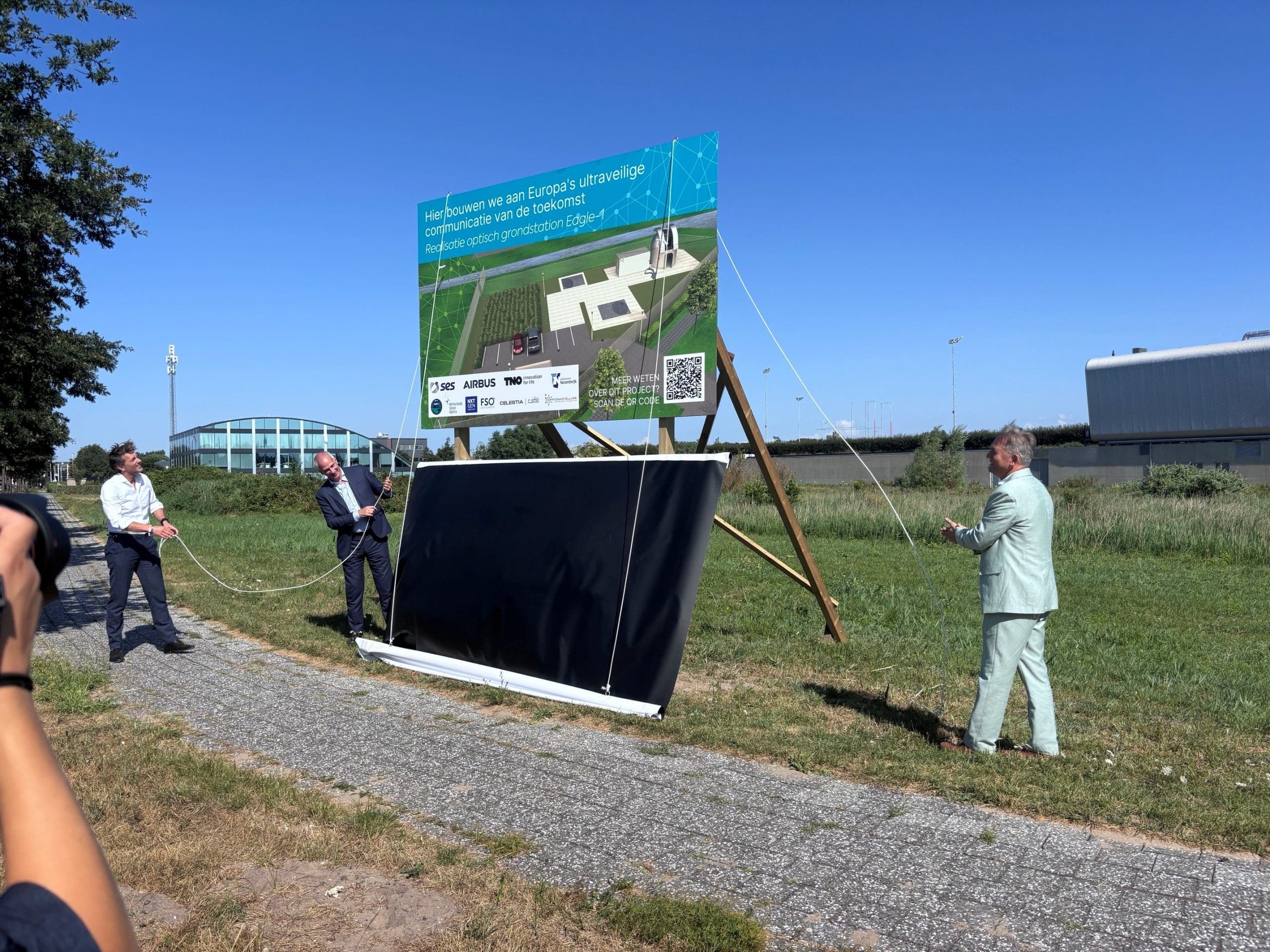 Wethouder Pim van Strien, Rob Postema van Airbus Nederland en Alan Kuresevic van SES onthullen het bouwbord van het optische grondstation