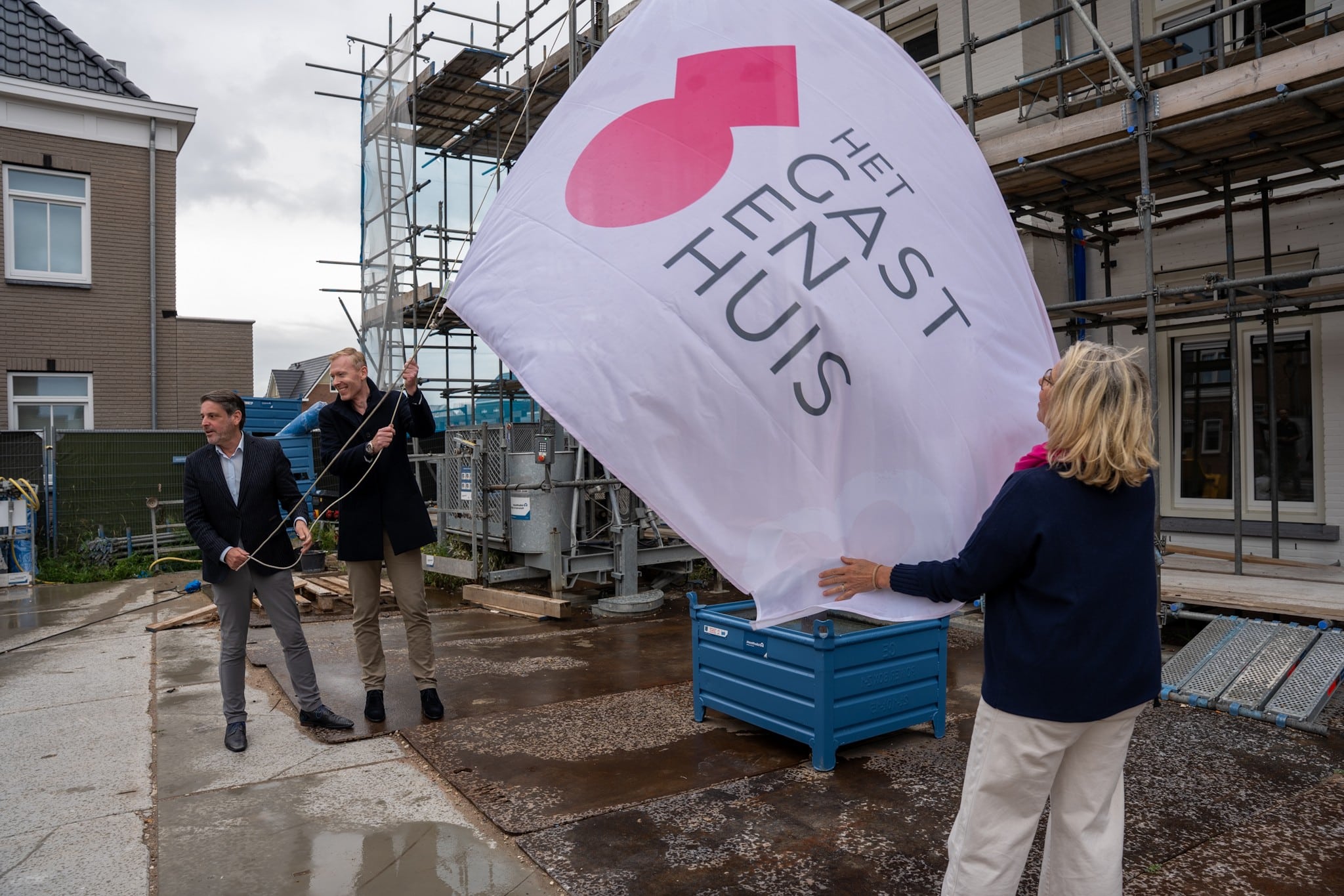 Wethouder Dennis Salman hijst de vlag van Het Gastenhuis op de locatie waar dit wordt gebouwd