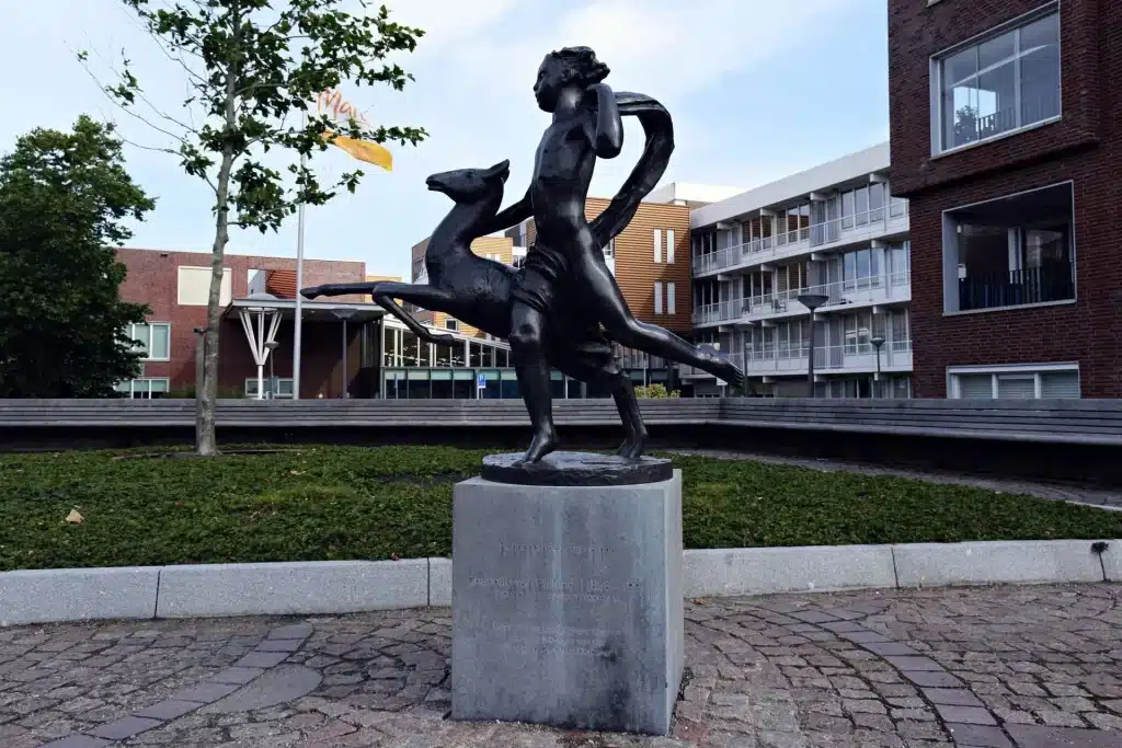 Beeld Rennend naakt met hinde op hoek van kruispunt.
