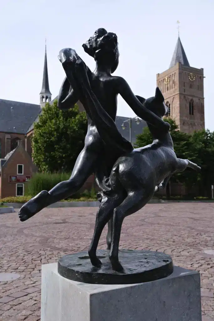 Beeld Rennend naakt met hinde op hoek van kruispunt.