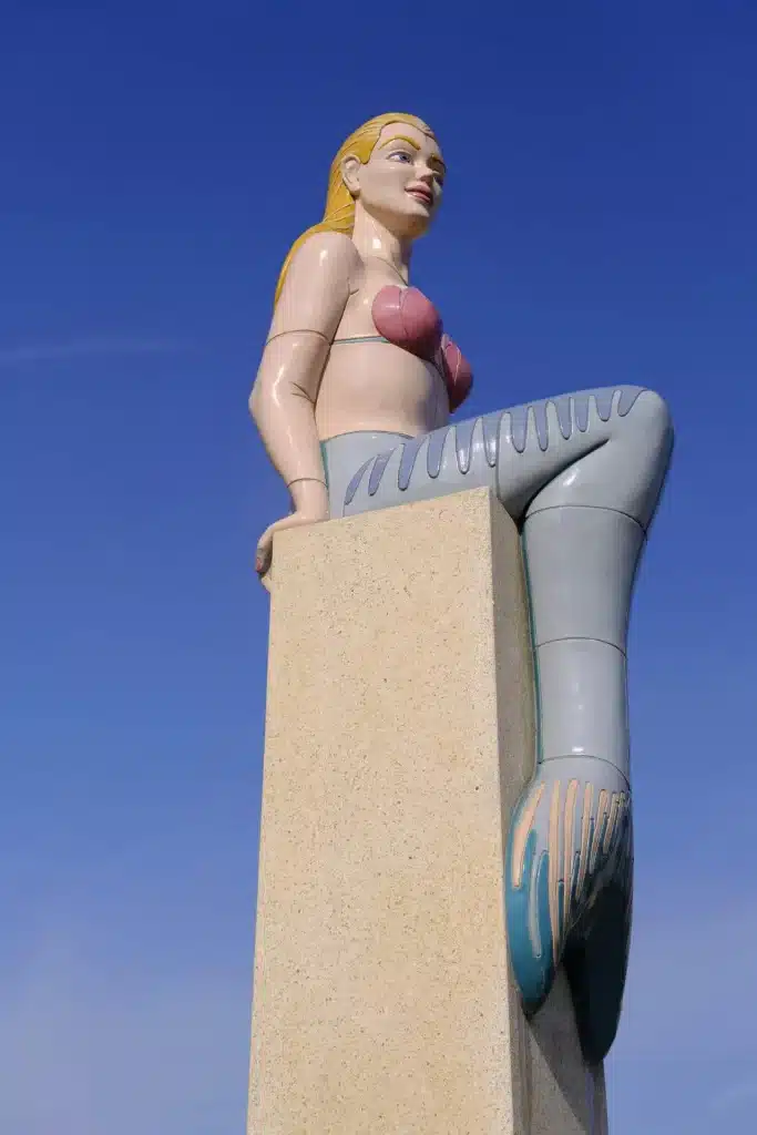 Beeld van een zeemeermin van onderaf genomen.