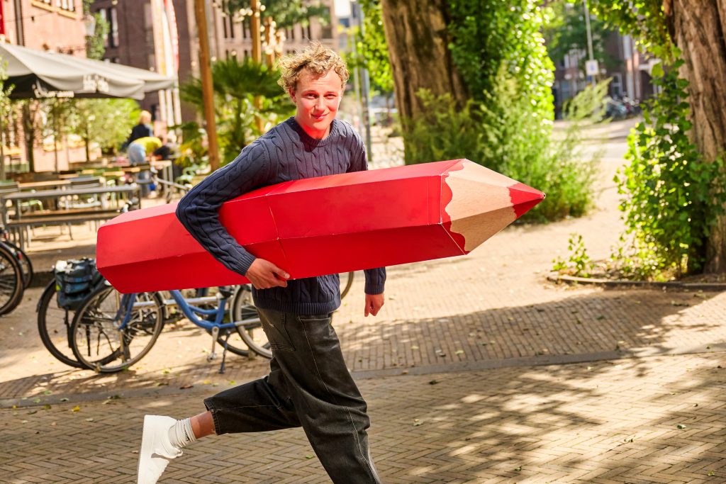 Man met groot rood potlood klaar om te stemmen.